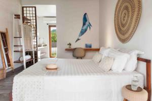 a bedroom with a large white bed with a blue dolphin on the wall at Odoyá Casa Hotel in Paraty +66 photos