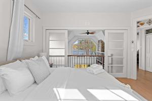 a white bed with white pillows in a bedroom at Waterfront with VIEW and SPA in Saint-Raymond