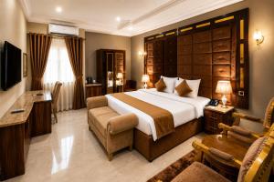 a hotel room with a large bed and a television at Grand Bohabs Hotel in Abuja