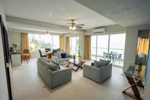 a living room with couches and a table and chairs at Blue Chairs Beachfront Resort Puerto Vallarta - Adults Only in Puerto Vallarta