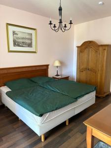 a bedroom with a bed and a chandelier at Altes Gutshaus Schwiessel in Prebberede +28 photos