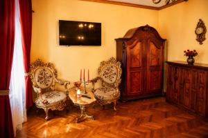 a room with a table and two chairs and a tv at History Apartments Cetății in Sibiu