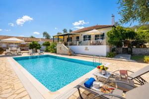 a swimming pool in front of a house at Villa Afroditi in Kourtaíïka