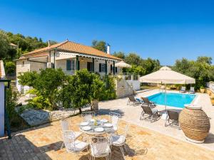 a patio with a table and chairs and a pool at Villa Afroditi in Kourtaíïka