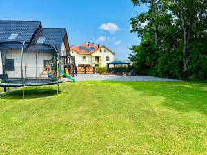 a large yard with a playground and a house at Na Fali Marszałka in Mielenko
