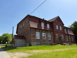 a large red brick building with white windows at Altes Gutshaus Schwiessel in Prebberede