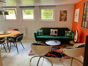 a living room with a green couch and a table at Le Gîte de Brigitte ! in Saint Die