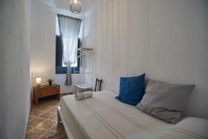 a bedroom with a bed with blue pillows and a window at Casa Cercana in Abarán