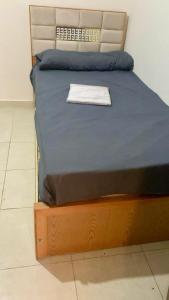 a bed with a wooden frame with a blue blanket at Biu Bela abartment hotel in El Alamein