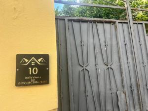a metal gate with a sign next to a yellow wall at Galliu'S home in Selargius