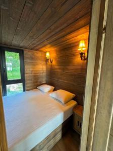a bed in a wooden room with two pillows at Beržų oazės spa in Molėtai