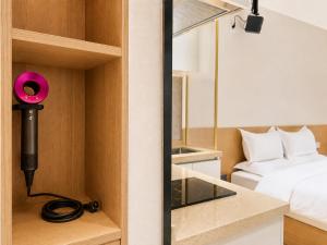 a room with a bed and a pink camera on a shelf at Ancient City Garden Luxury Residence Xian in Xi'an