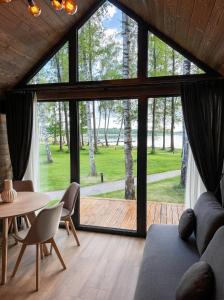 a living room with a large window and a table and chairs at Beržų oazės spa in Molėtai