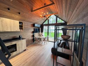 a kitchen and dining room of a house with wooden walls at Beržų oazės spa in Molėtai