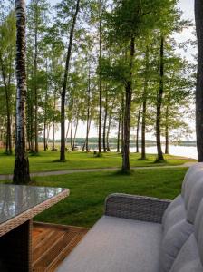 a patio with a table and a view of a park at Beržų oazės spa in Molėtai +8 photos