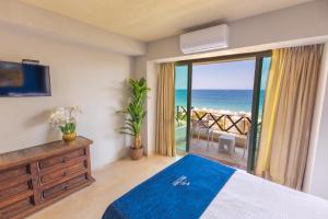 a bedroom with a bed and a view of the ocean at Blue Chairs Beachfront Resort Puerto Vallarta - Adults Only in Puerto Vallarta +56 photos