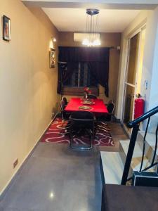 a dining room with a red table and chairs at Sandvica Luxe Homes in Port Harcourt