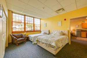 a bedroom with two beds and a chair at Work, Play & Explore: 9-Unit New Kensington Base in New Kensington