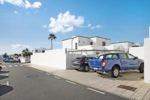 two cars parked in a parking lot in front of a house at Kays studio in Puerto del Carmen