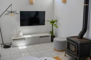 a living room with a fireplace and a tv at Casa Dos Amigos in Budens