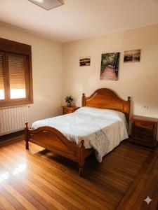a bedroom with a bed and a wooden floor at A Veiga Grande in Pontevedra
