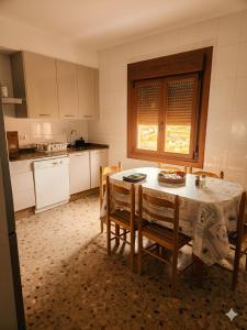 a kitchen with a table and chairs and a table and a window at A Veiga Grande in Pontevedra