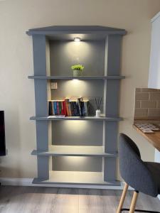 a blue book shelf with books on it at Sperrin Way Apartment in Newtownstewart