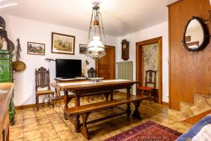 a dining room with a wooden table and a television at Gîte Éclat De Soleil in Beblenheim