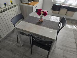 a dining room table with a vase of flowers on it at La Casa di Nonna Mari in Moneglia +25 photos