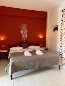 a bedroom with a large bed with red walls at Yannis Apartments in Afitos
