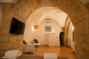 a living room with a tv in a stone wall at Cadelli Luxury Suite & Apartments in Lecce