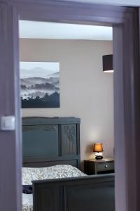 a bedroom with a bed with a painting on the wall at La Curiosité in Barr +3 photos