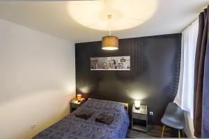 a small bedroom with a bed and a ceiling at La Curiosité in Barr