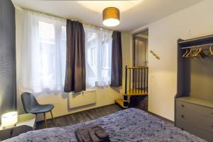 a bedroom with a bed and a chair and a window at La Curiosité in Barr