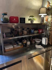 a kitchen counter with a shelf with dishes and a lamp at Noce Rooms Zagreb in Zagreb