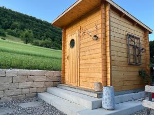 a small wooden building with steps in front of a field at B&B Alpenblick in Erlinsbach
