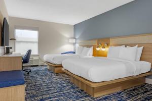 a hotel room with two beds and a desk at Best Western St. Louis Fairview Heights in Fairview Heights