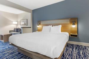 a hotel room with a large bed and a chair at Best Western St. Louis Fairview Heights in Fairview Heights +35 photos