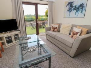 a living room with a couch and a glass table at Ryecross Farm Cottage in Melbury Abbas