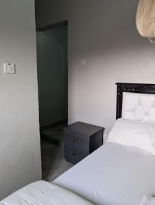 a bedroom with two beds and a nightstand next to a bed at Nandyowa Guesthouse in Kampala