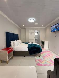 a bedroom with a large bed and a tv at The Perfect Place in Parow