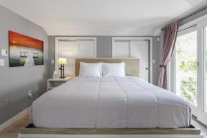 a bedroom with a large white bed and a window at The Viewpoint in Provincetown