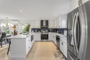 a kitchen with white cabinets and a stainless steel refrigerator at The Viewpoint in Provincetown