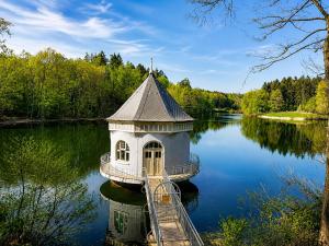 a small building in the middle of a lake at Gelbe Koffer - Design-Apartment in Schiffweiler - 2 Parkplätze - Self-Check-in - ruhig & naturnah in Schiffweiler +30 photos