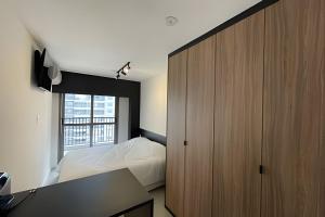 a bedroom with a bed and a large wooden cabinet at Studio 810 | Completo e Novo | SP Expo e Congonhas in São Paulo +104 photos