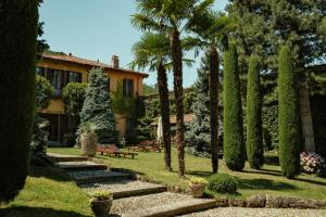 a garden with palm trees and a house at Villa Wirnica Lake Como in Garlate