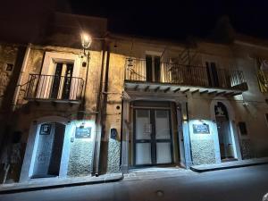 a building with a door and a balcony at night at Kandinsky CASA VACANZE Relax in Monterosso Almo