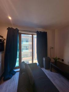 a living room with a couch and a large window at Central Sheffield Studio for 2 in Sheffield