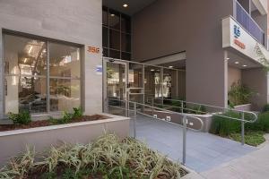 a building with glass doors and plants in front of it at Studio 810 | Completo e Novo | SP Expo e Congonhas in São Paulo
