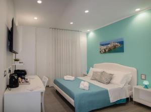 a bedroom with a bed and a desk and a television at Donna Marianna in Vieste